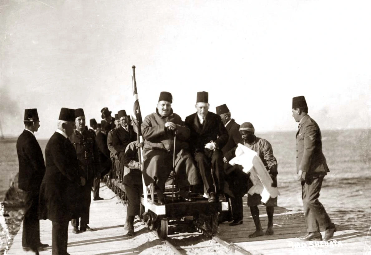 King Faud on the narrow gauge railway that connected El Quseir port with the  mines. Judging by the clothing, it might  have been the 28 December 1926 trip. Public domain via Wikimedia.