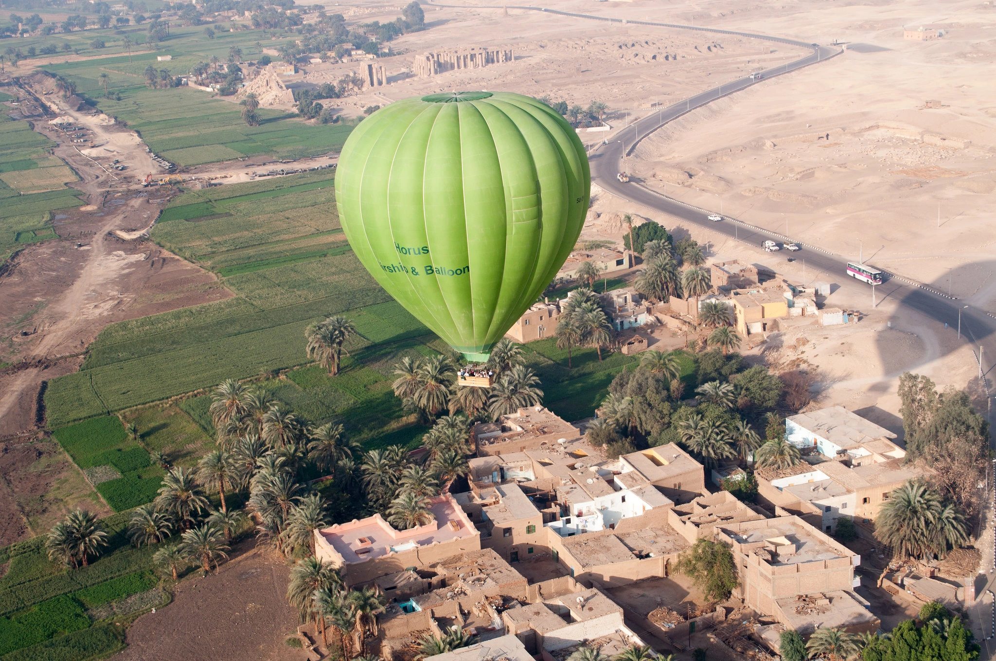 A hot air balloon drifts over rooftops
towards the mortuary temple of Ramses II
Photo credit: Naka Kei CC0 1.0 via Flickr.